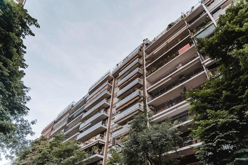 Residential apartment building with balconies and greenery in a Spanish city, representing the urban property investment market