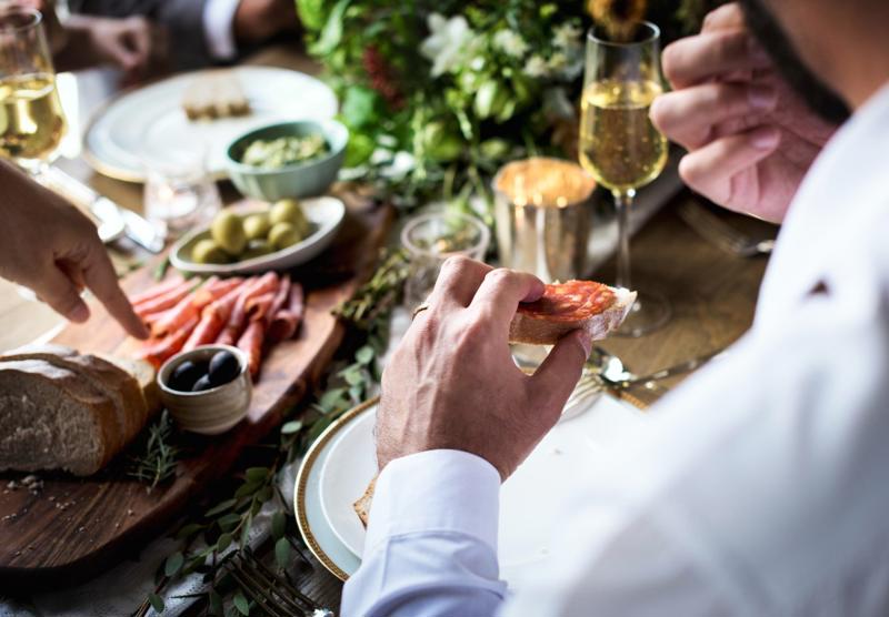Colleagues sharing tapas, wine and conversation at a business lunch, reflecting the relationship-focused nature of work in Spain