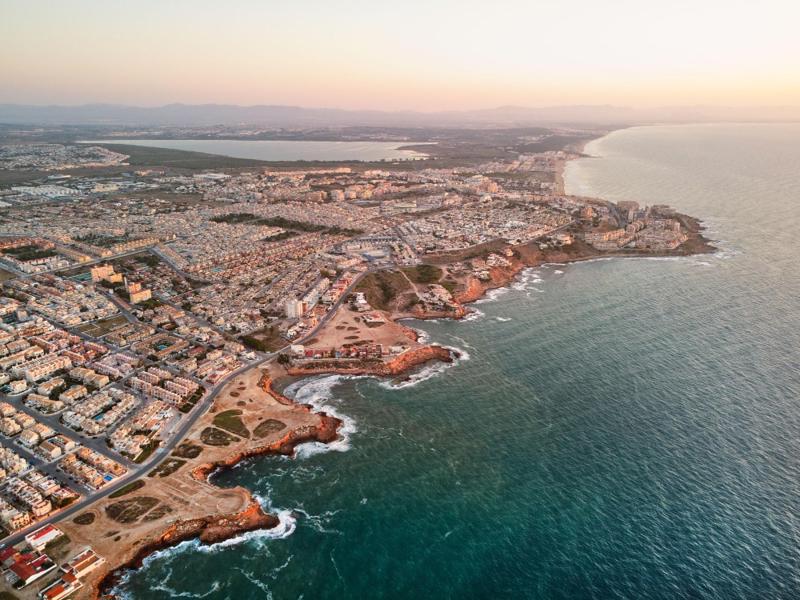 Aerial view of a Spanish coastal town with residential developments along the Mediterranean coastline